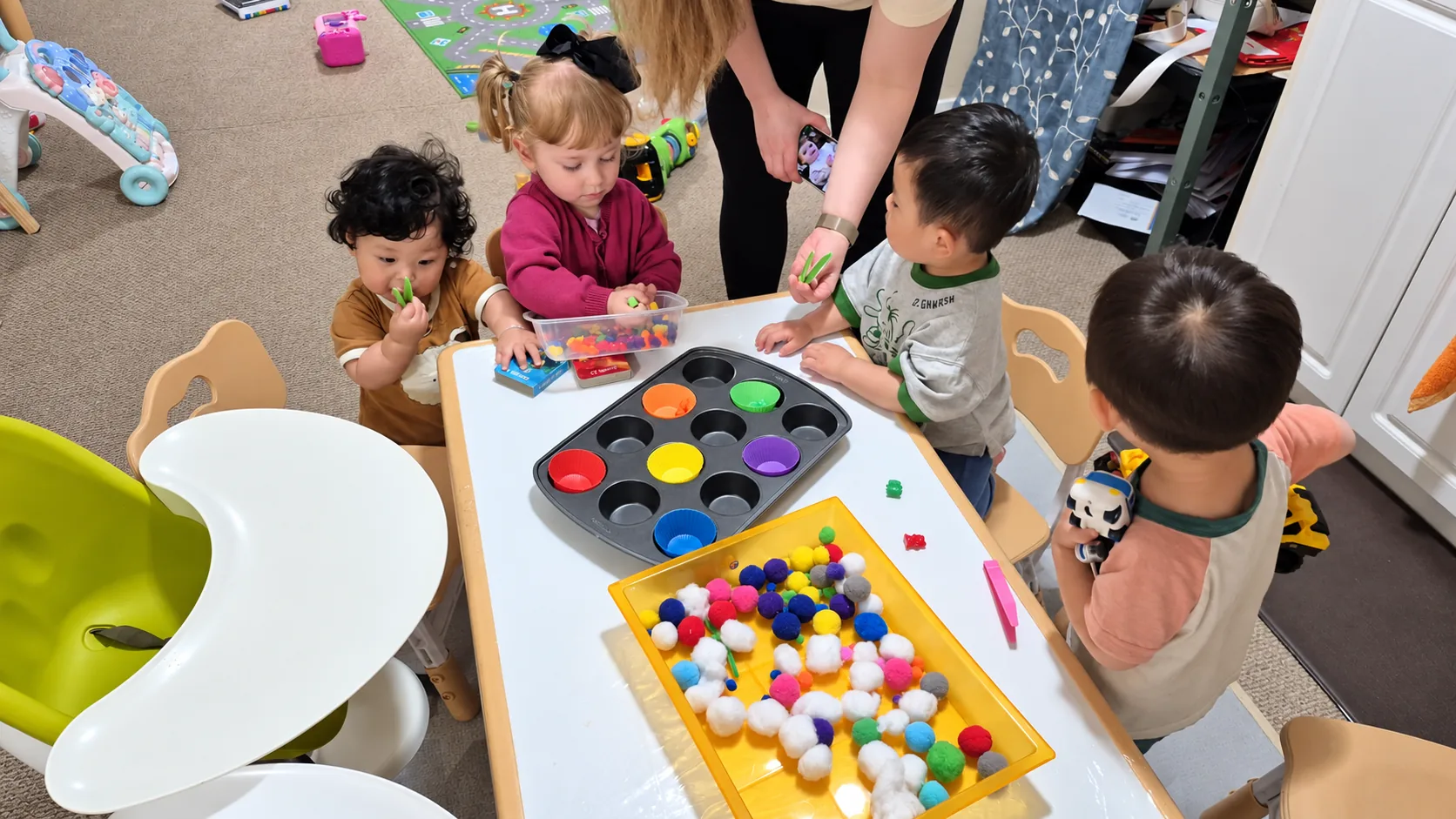 Children exploring colours and sorting materials with their educator