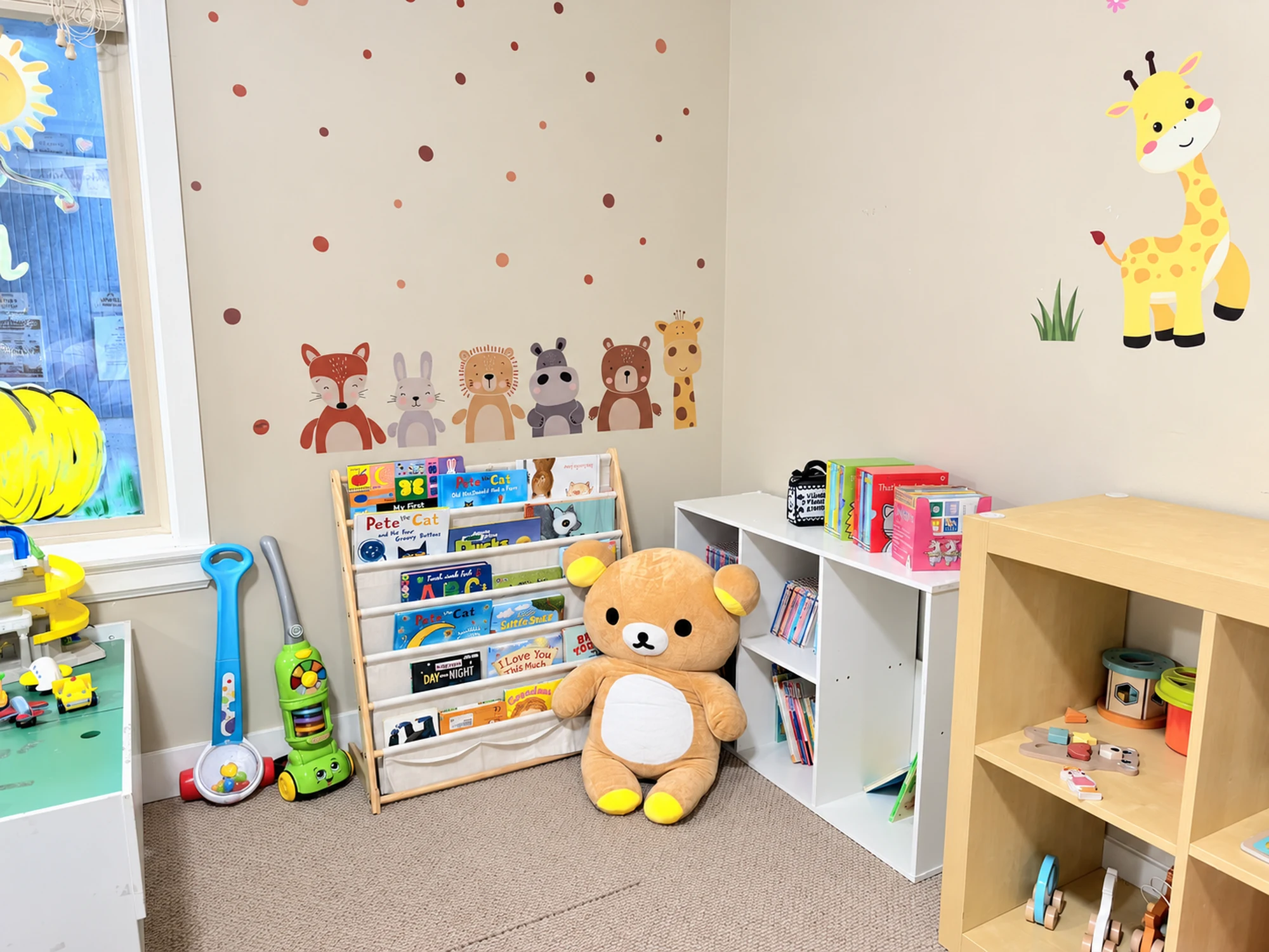 The book and quiet-play corner at I Love Childcare, with a low bookshelf and teddy bear.